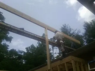Carpenter setting a ridge beam over a new addition frame — Ice Dam Removal by Roofing Brothers in Port Ludlow