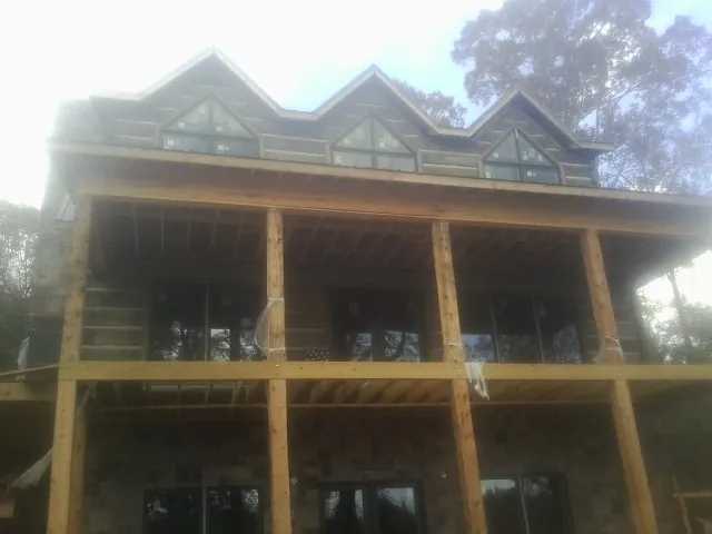Dormers and porch framing on a large log home under construction — Roof Coating work by our crew in Port Ludlow