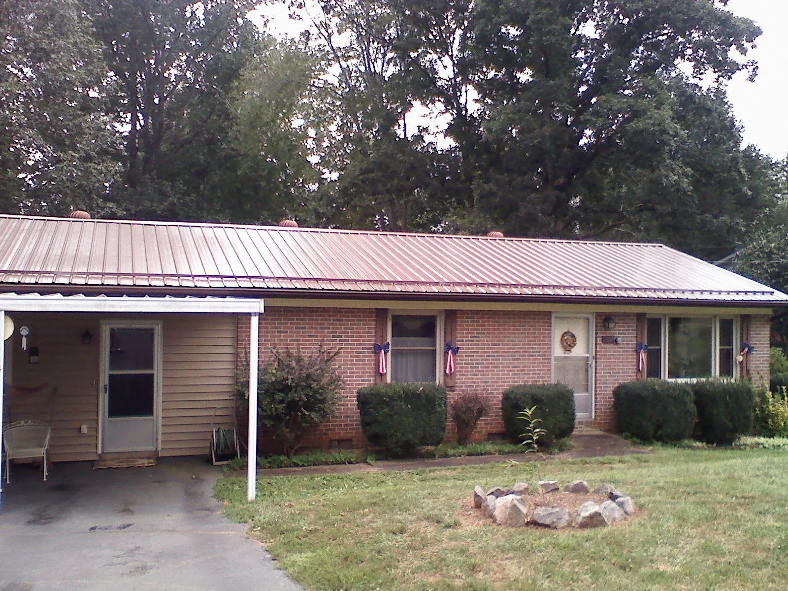 Bronze metal roof and carport on a brick ranch home — Roof Repair work by our crew in Port Ludlow